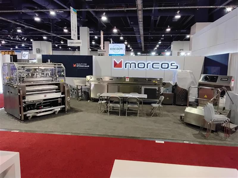 Industrial exhibit with stainless-steel equipment arranged around a central service area.